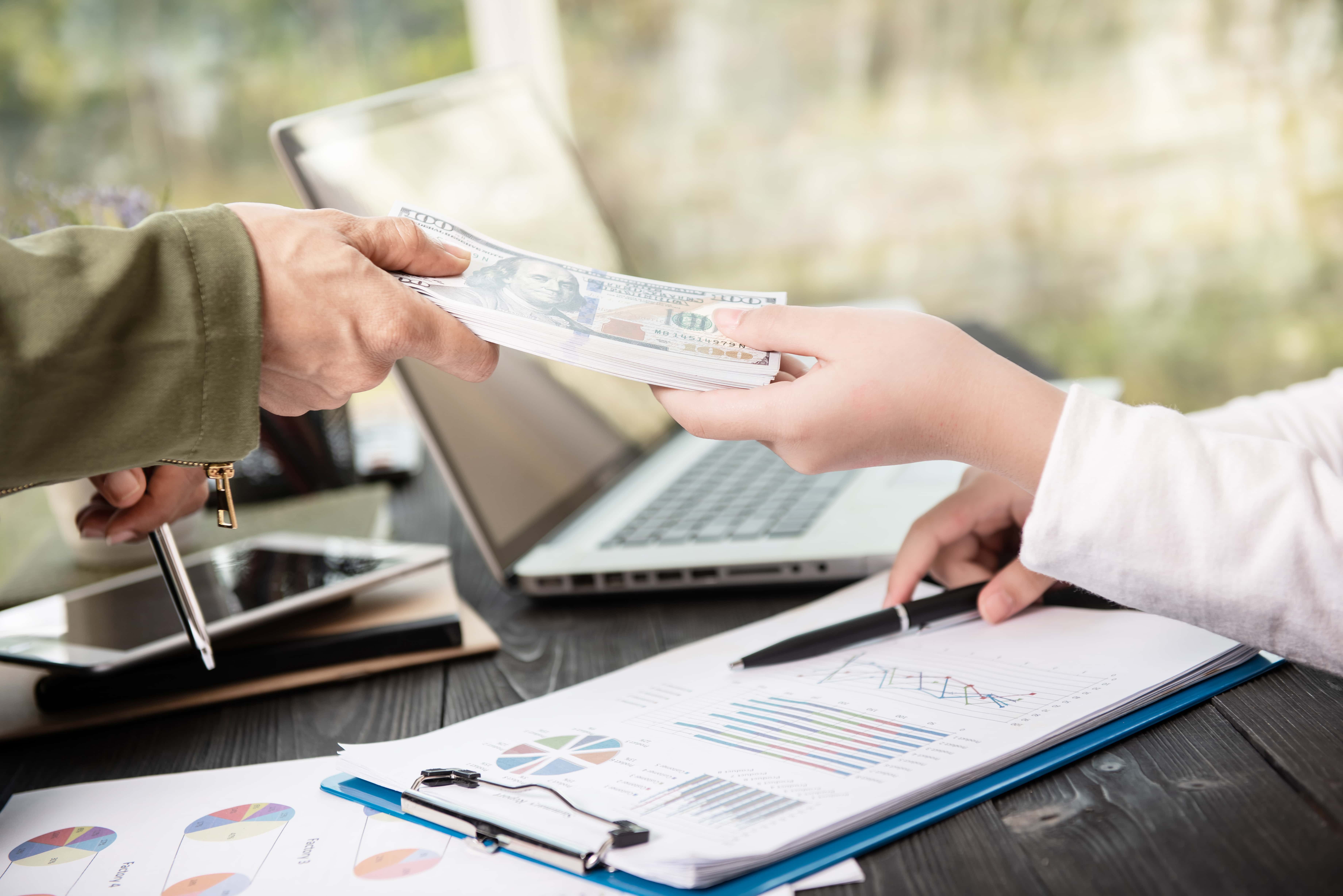 Businessman giving money his partner while making contract